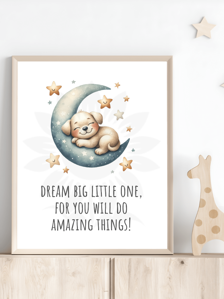 Nursery room decor with framed wall art of a cute puppy sleeping on a crescent moon and the text 'DREAM BIG LITTLE ONE, FOR YOU WILL DO AMAZING THINGS!' The design, from Blossoming Minds, is displayed on a shelf next to a wooden giraffe toy, encouraging positive affirmations and dreaming big for children